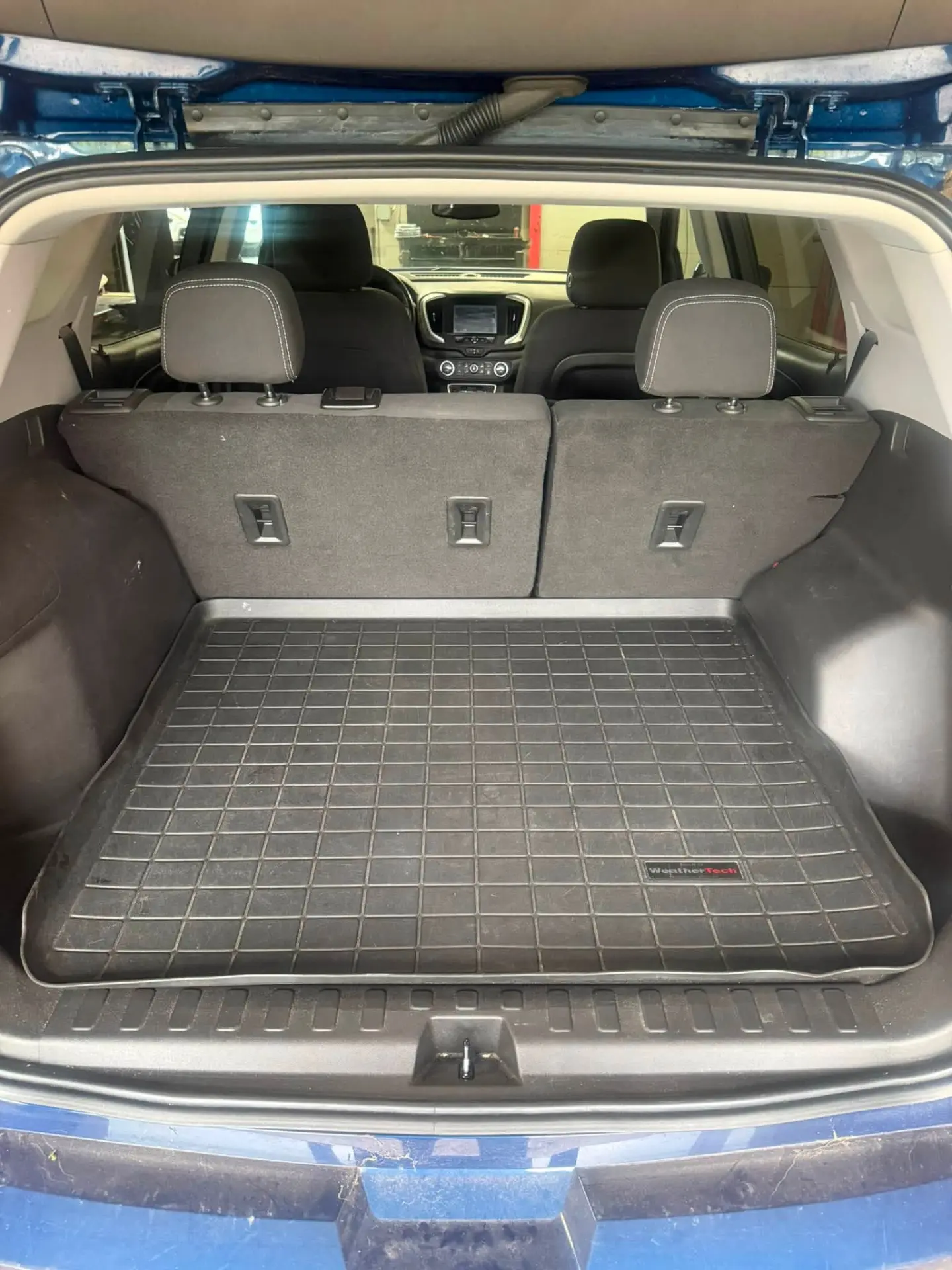 Vacuumed cargo area and rear seats with cleaned floor liner